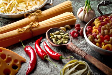 Makarna sebze ve eski bir arka plan üzerinde mutfak aksesuarları ile bir kompozisyon içinde