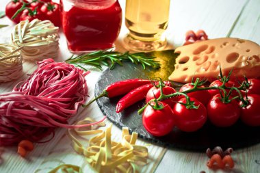 Makarna sebze ve eski bir arka plan üzerinde mutfak aksesuarları ile bir kompozisyon içinde