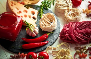 Makarna sebze ve eski bir arka plan üzerinde mutfak aksesuarları ile bir kompozisyon içinde