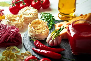 Makarna sebze ve eski bir arka plan üzerinde mutfak aksesuarları ile bir kompozisyon içinde