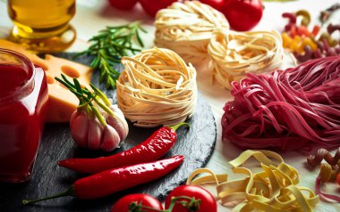 Makarna sebze ve eski bir arka plan üzerinde mutfak aksesuarları ile bir kompozisyon içinde