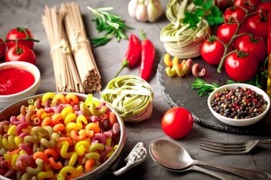 Makarna sebze ve eski bir arka plan üzerinde mutfak aksesuarları ile bir kompozisyon içinde