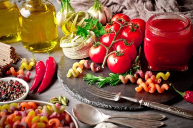 Makarna sebze ve eski bir arka plan üzerinde mutfak aksesuarları ile bir kompozisyon içinde