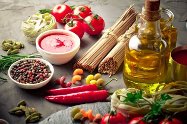Makarna sebze ve eski bir arka plan üzerinde mutfak aksesuarları ile bir kompozisyon içinde