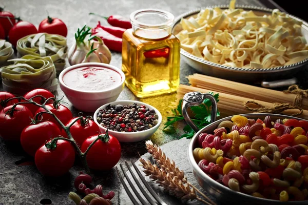 Makarna sebze ve eski bir arka plan üzerinde mutfak aksesuarları ile bir kompozisyon içinde