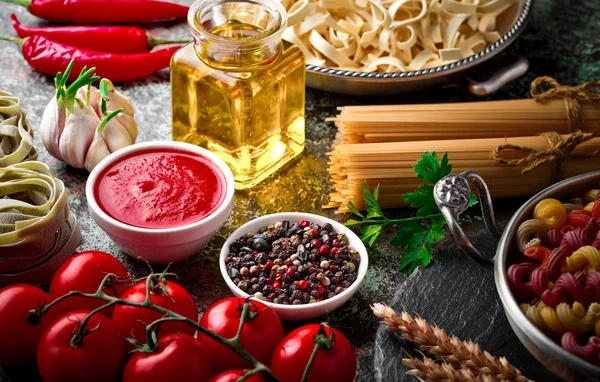 Makarna sebze ve eski bir arka plan üzerinde mutfak aksesuarları ile bir kompozisyon içinde