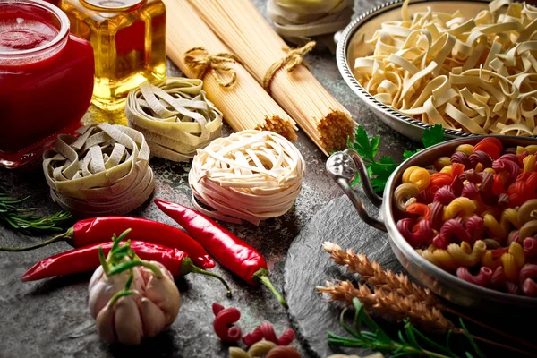 Makarna sebze ve eski bir arka plan üzerinde mutfak aksesuarları ile bir kompozisyon içinde