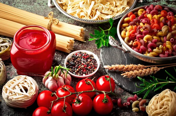 Makarna sebze ve eski bir arka plan üzerinde mutfak aksesuarları ile bir kompozisyon içinde