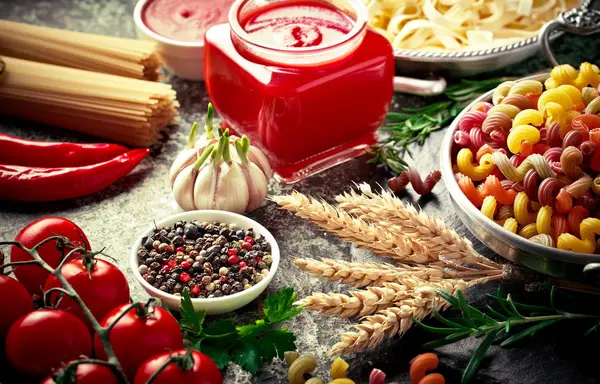 Makarna sebze ve eski bir arka plan üzerinde mutfak aksesuarları ile bir kompozisyon içinde