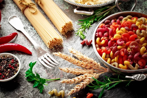 Makarna sebze ve eski bir arka plan üzerinde mutfak aksesuarları ile bir kompozisyon içinde