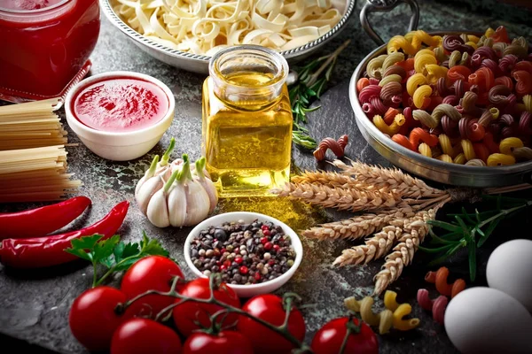 Makarna sebze ve eski bir arka plan üzerinde mutfak aksesuarları ile bir kompozisyon içinde