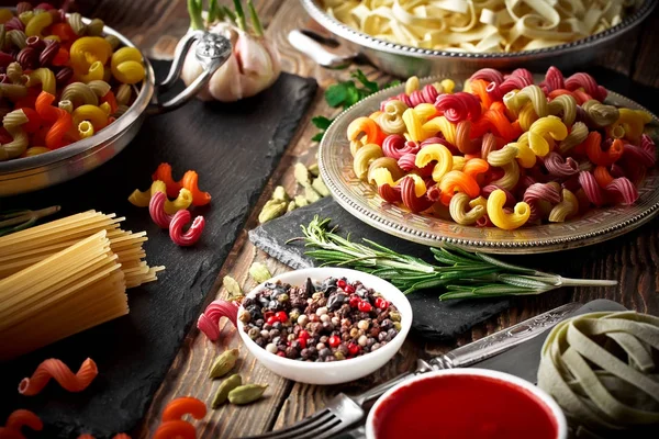 Makarna sebze ve eski bir arka plan üzerinde mutfak aksesuarları ile bir kompozisyon içinde