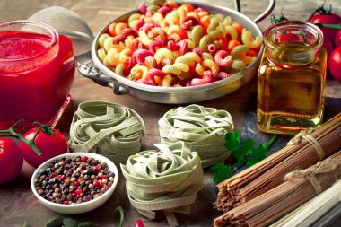 Makarna sebze ve eski bir arka plan üzerinde mutfak aksesuarları ile bir kompozisyon içinde