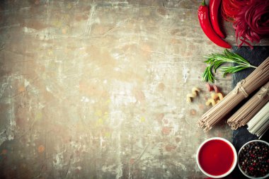 Makarna sebze ve eski bir arka plan üzerinde mutfak aksesuarları ile bir kompozisyon içinde