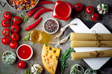 Makarna sebze ve eski bir arka plan üzerinde mutfak aksesuarları ile bir kompozisyon içinde