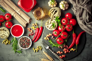 Makarna sebze ve eski bir arka plan üzerinde mutfak aksesuarları ile bir kompozisyon içinde