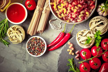 Makarna sebze ve eski bir arka plan üzerinde mutfak aksesuarları ile bir kompozisyon içinde