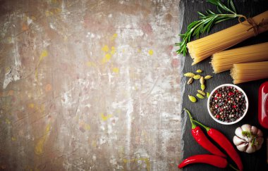 Makarna sebze ve eski bir arka plan üzerinde mutfak aksesuarları ile bir kompozisyon içinde