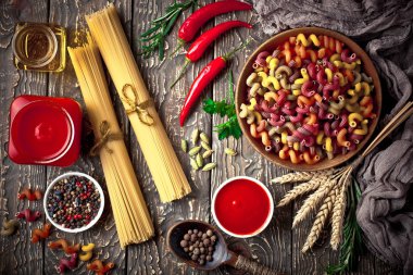 Makarna sebze ve eski bir arka plan üzerinde mutfak aksesuarları ile bir kompozisyon içinde