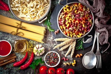 Makarna sebze ve eski bir arka plan üzerinde mutfak aksesuarları ile bir kompozisyon içinde