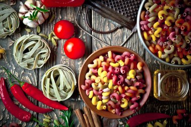 Makarna sebze ve eski bir arka plan üzerinde mutfak aksesuarları ile bir kompozisyon içinde