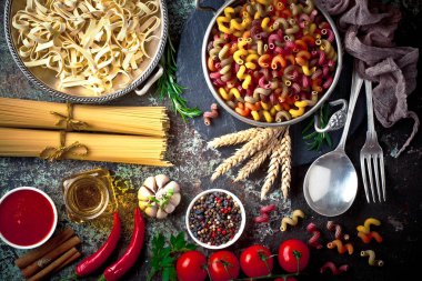 Makarna sebze ve eski bir arka plan üzerinde mutfak aksesuarları ile bir kompozisyon içinde