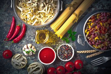 Makarna sebze ve eski bir arka plan üzerinde mutfak aksesuarları ile bir kompozisyon içinde