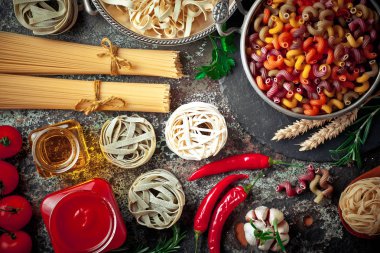 Makarna sebze ve eski bir arka plan üzerinde mutfak aksesuarları ile bir kompozisyon içinde