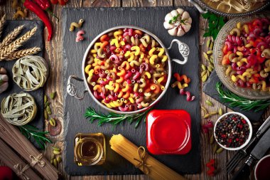 Makarna sebze ve eski bir arka plan üzerinde mutfak aksesuarları ile bir kompozisyon içinde