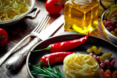 Makarna sebze ve eski bir arka plan üzerinde mutfak aksesuarları ile bir kompozisyon içinde