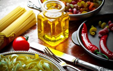 Makarna sebze ve eski bir arka plan üzerinde mutfak aksesuarları ile bir kompozisyon içinde