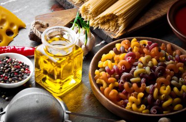 Makarna sebze ve eski bir arka plan üzerinde mutfak aksesuarları ile bir kompozisyon içinde