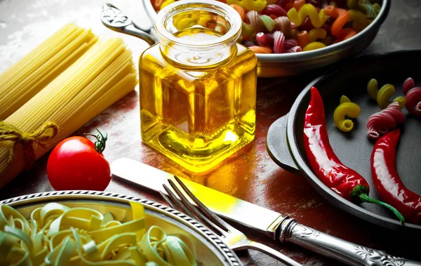 Makarna sebze ve eski bir arka plan üzerinde mutfak aksesuarları ile bir kompozisyon içinde