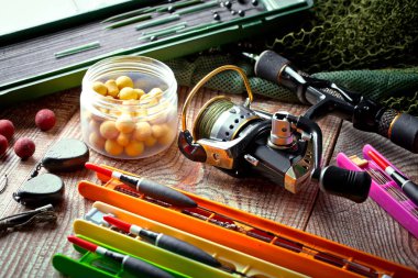 Balıkçılık çubuklar ve spinnings tablosundaki eski arka plan üzerinde balıkçılık için aksesuarlar ile kompozisyon