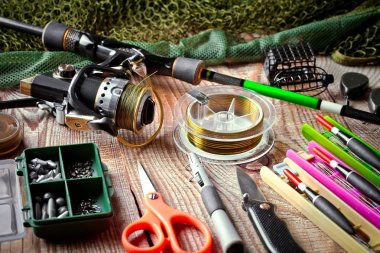 Balıkçılık çubuklar ve spinnings tablosundaki eski arka plan üzerinde balıkçılık için aksesuarlar ile kompozisyon