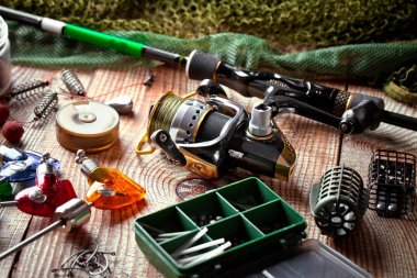 Balıkçılık çubuklar ve spinnings tablosundaki eski arka plan üzerinde balıkçılık için aksesuarlar ile kompozisyon