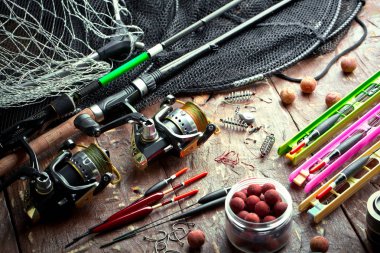 Balıkçılık çubuklar ve spinnings tablosundaki eski arka plan üzerinde balıkçılık için aksesuarlar ile kompozisyon
