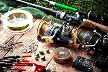 Balıkçılık çubuklar ve spinnings tablosundaki eski arka plan üzerinde balıkçılık için aksesuarlar ile kompozisyon