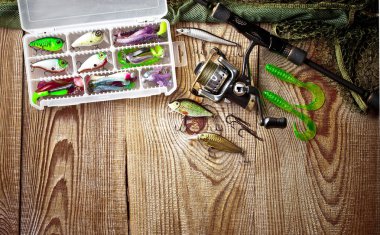 Balıkçılık çubuklar ve spinnings tablosundaki eski arka plan üzerinde balıkçılık için aksesuarlar ile kompozisyon