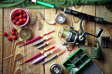 Balıkçılık çubuklar ve spinnings tablosundaki eski arka plan üzerinde balıkçılık için aksesuarlar ile kompozisyon