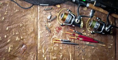 Balıkçılık çubuklar ve spinnings tablosundaki eski arka plan üzerinde balıkçılık için aksesuarlar ile kompozisyon