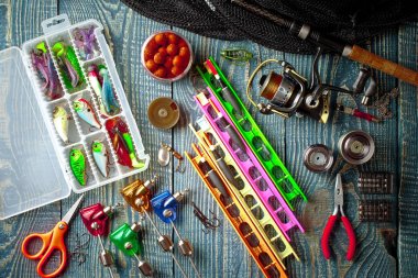 Balıkçılık çubuklar ve spinnings tablosundaki eski arka plan üzerinde balıkçılık için aksesuarlar ile kompozisyon