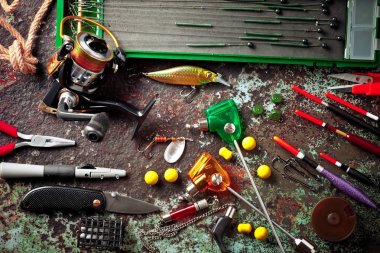 Balıkçılık çubuklar ve spinnings tablosundaki eski arka plan üzerinde balıkçılık için aksesuarlar ile kompozisyon