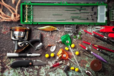 Balıkçılık çubuklar ve spinnings tablosundaki eski arka plan üzerinde balıkçılık için aksesuarlar ile kompozisyon