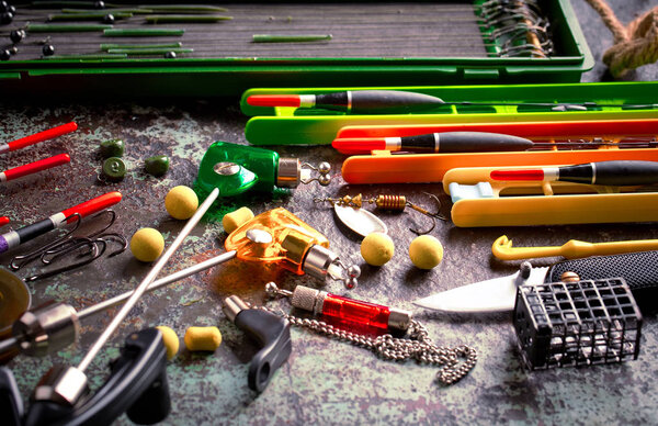 Fishing rods and spinnings in the composition with accessories for fishing on the old background on the table