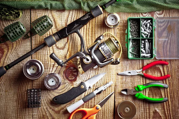 Balıkçılık çubuklar ve spinnings tablosundaki eski arka plan üzerinde balıkçılık için aksesuarlar ile kompozisyon