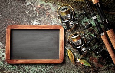 Balıkçılık çubuklar ve spinnings tablosundaki eski arka plan üzerinde balıkçılık için aksesuarlar ile kompozisyon