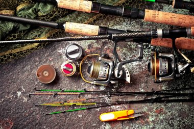 Balıkçılık çubuklar ve spinnings tablosundaki eski arka plan üzerinde balıkçılık için aksesuarlar ile kompozisyon