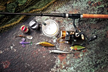 Balıkçılık çubuklar ve spinnings tablosundaki eski arka plan üzerinde balıkçılık için aksesuarlar ile kompozisyon