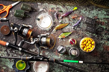 Balıkçılık çubuklar ve spinnings tablosundaki eski arka plan üzerinde balıkçılık için aksesuarlar ile kompozisyon
